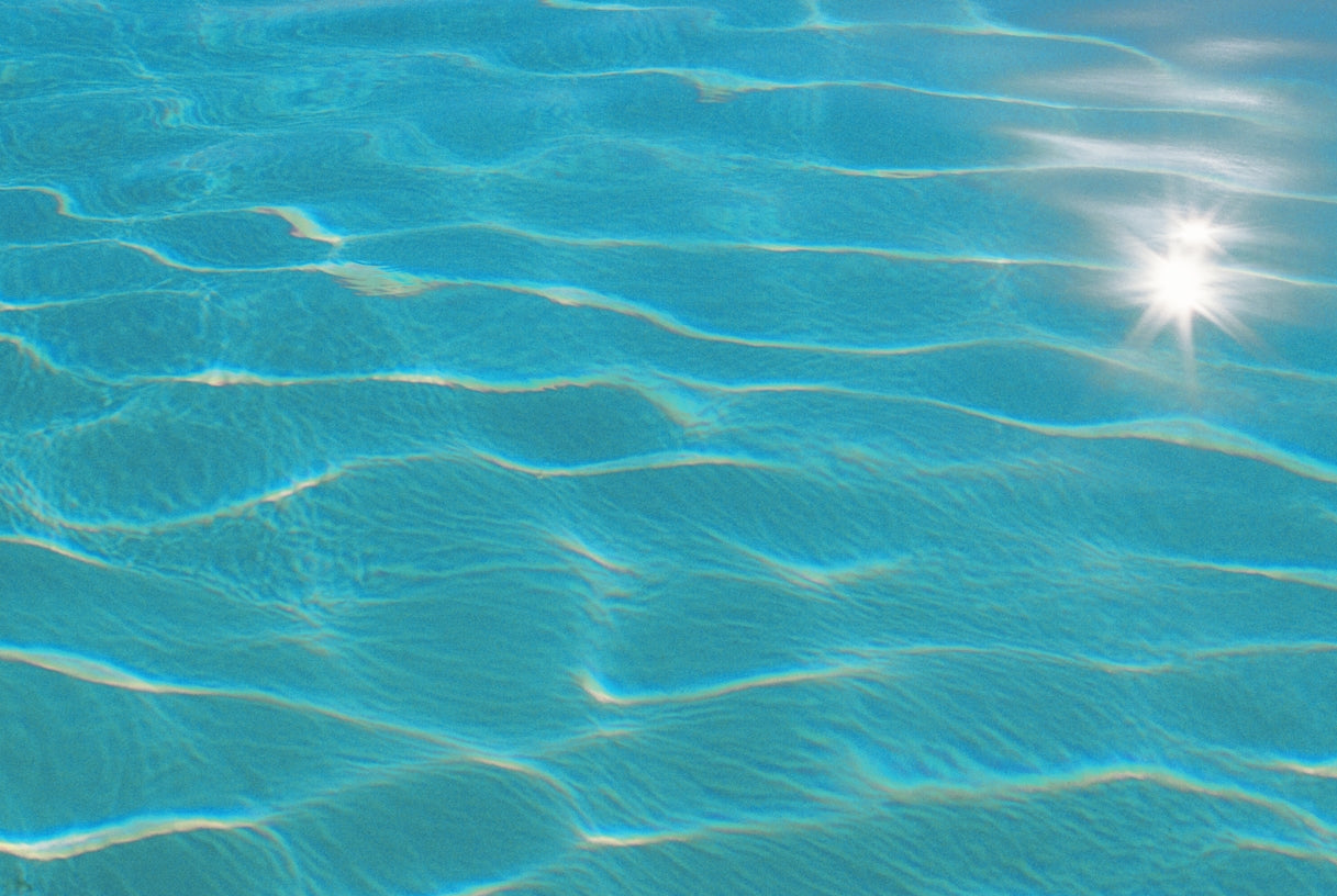 Clear blue water surface with sunlight reflecting on the water's surface