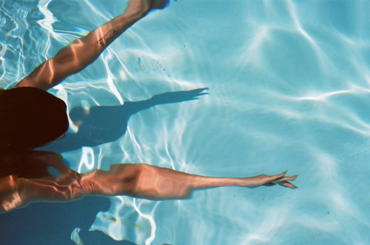 Person swimming underwater in clear blue water